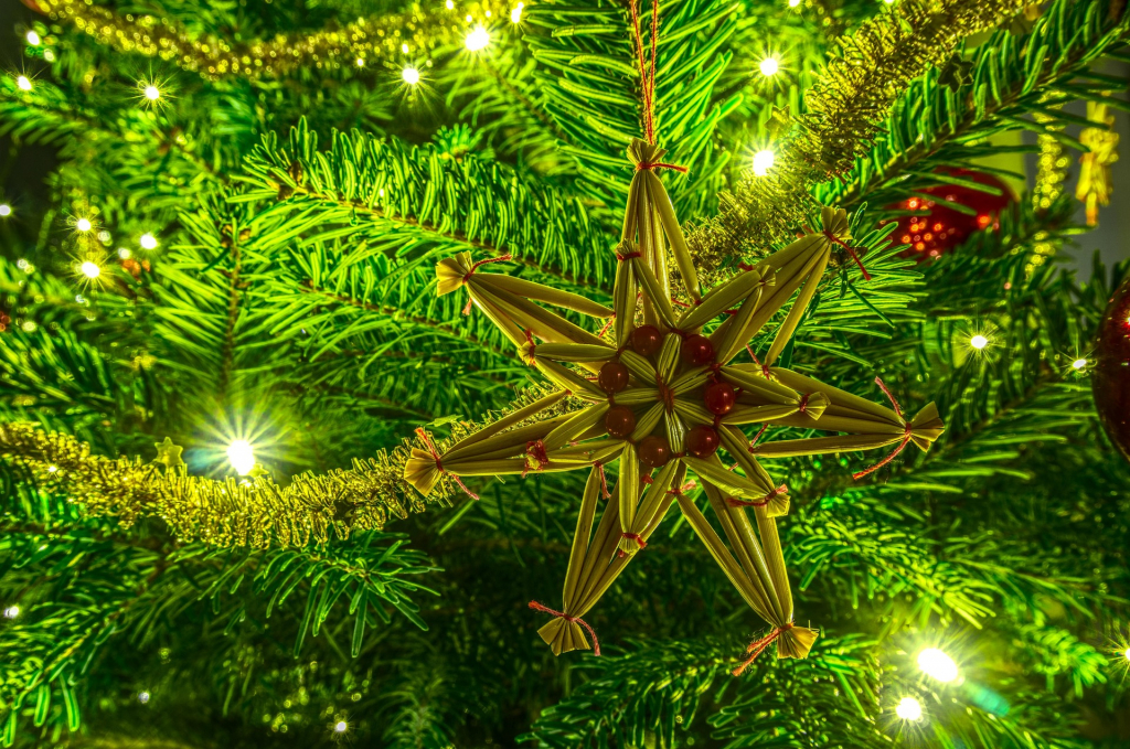 Strohstern und Lichter an Tannenbaum